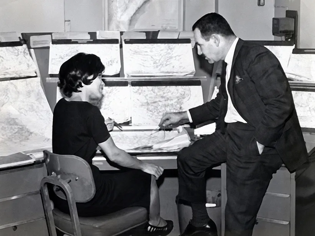 Bacon-Bercey conferring with a colleague