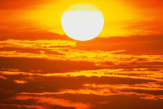Low-angled sun over clouds
