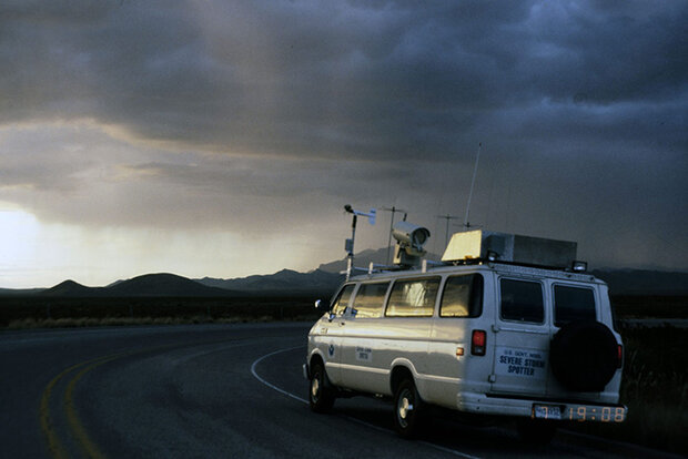 Van outfitted with observational gear, storm in distance